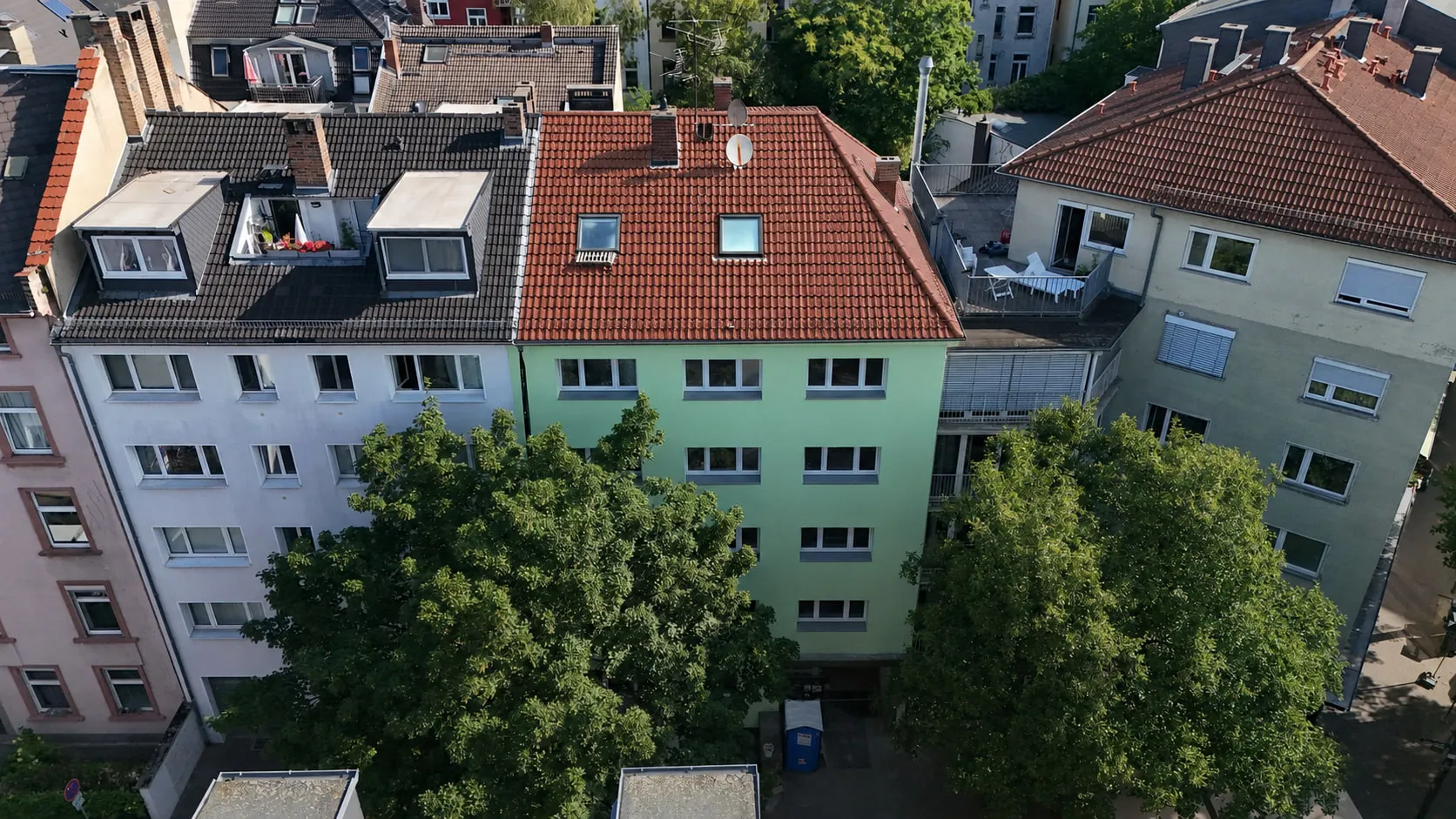 Das Wohnhaus des Projekts GREEN FOUR in Schwarzweiß, aus der Luft über die volle Breite, zwischen den Nachbarhäusern der Zeile.