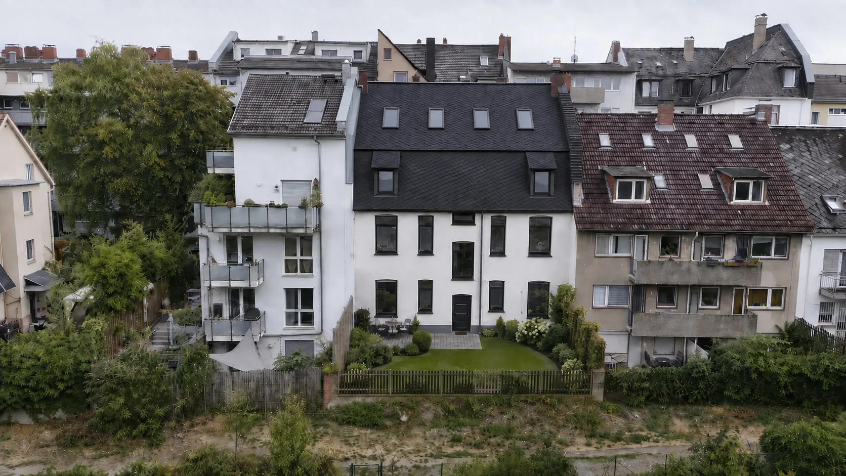 Die Gartenseite von BACKYARD 24 in Schwarzweiß, über die volle Breite zwischen den Nachbarhäusern des Blocks.