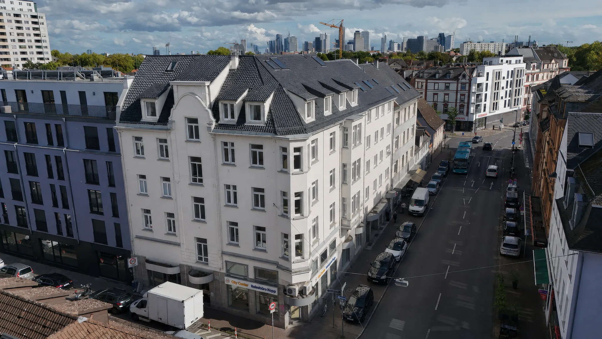 Das Eckhaus CORNER 36 in Schwarzweiß, aus der Luft über die volle Breite, zwischen den Nachbarhäusern des Blocks.