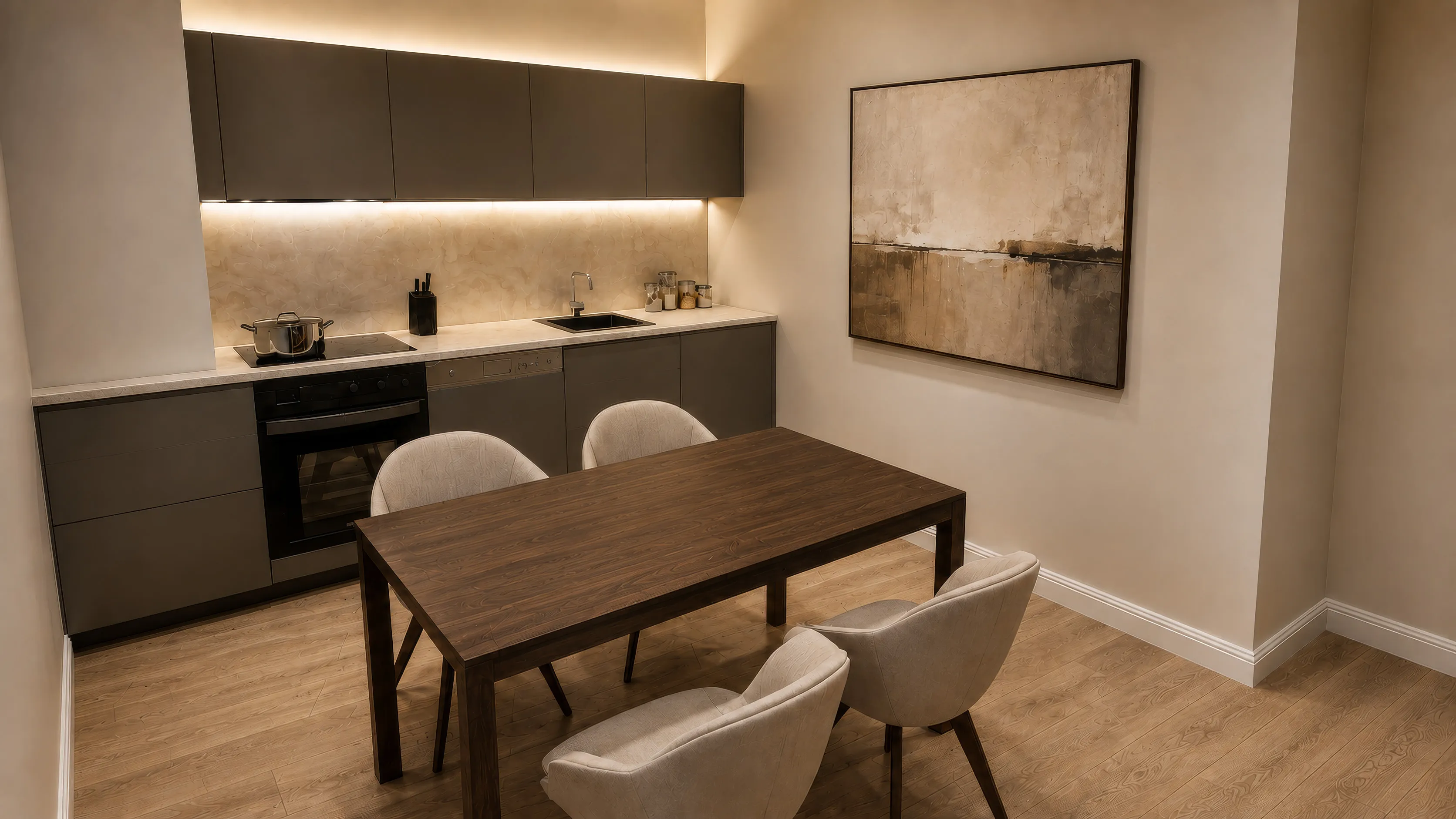 Küche einer Wohnung im Projekt CROWN 78: dunkelgraue grifflose Zeile mit indirektem Licht unter den Oberschränken, Kochfeld und eingebautem Backofen; davor ein Esstisch aus dunklem Holz mit vier hellen Polsterstühlen, rechts ein großformatiges Bild an der Wand, Dielenboden in Eichenoptik.